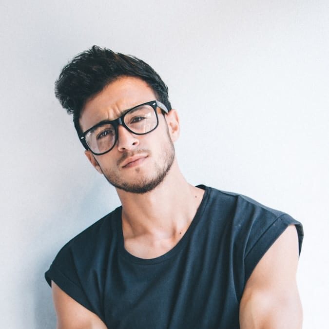 man wearing eyeglasses and sleeveless top